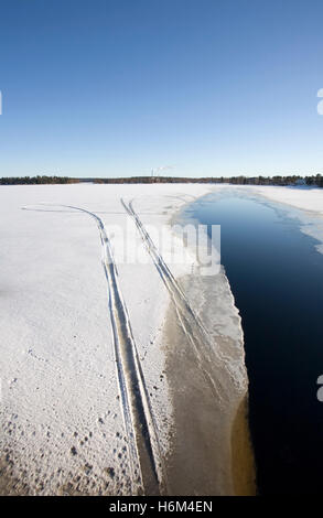 Snowmobile-Trails auf schmelzendem Eis, Finnland Stockfoto