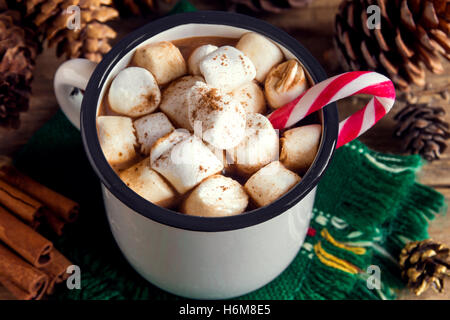 Heiße Schokolade mit Marshmallows, Pfefferminz Zuckerstangen und Zimtstangen in Vintage Metall Becher - hausgemachte festliches Heißgetränk Stockfoto