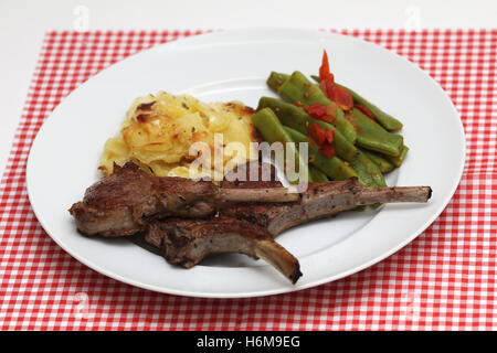 Lammkoteletts mit Kartoffelgratin und grünen Bohnen Stockfoto
