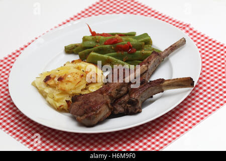 Lammkoteletts mit Kartoffelgratin und grünen Bohnen Stockfoto