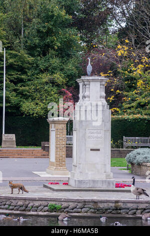 Ein Graureiher auf Carshalton Kriegerdenkmal von E.H. Bouchier, 1921, mit einem Fuchs und Kanadagans tatenlos, Surrey, England Stockfoto