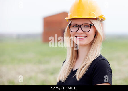 Junge Architekten mit gelben Helm in der Nähe seines Arbeitsplatzes Stockfoto