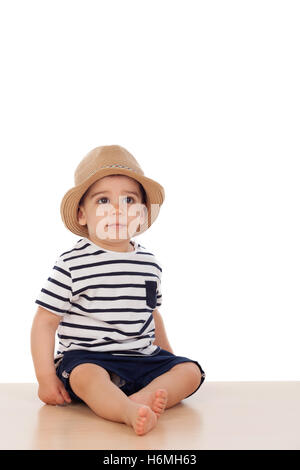 Neun Monate altes Baby mit Matrosen-Look auf dem Boden sitzend Stockfoto