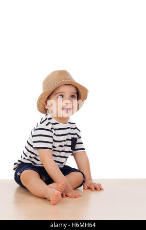 Neun Monate altes Baby mit Matrosen-Look auf dem Boden sitzend Stockfoto