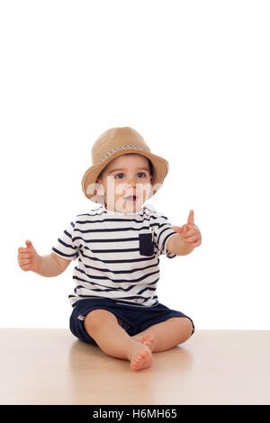 Neun Monate altes Baby mit Matrosen-Look auf dem Boden sitzend Stockfoto