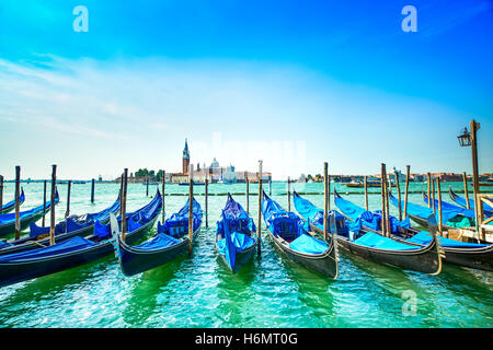 Venedig, Gondeln oder Gondeln auf einem blauen Himmel und San Giorgio Maggiore Kirche Wahrzeichen auf Hintergrund. Italien, Europa. Stockfoto