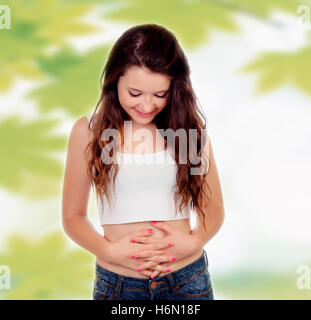 Teen Frau berühren ihren Bauch auf einem Hintergrund mit Blättern Stockfoto