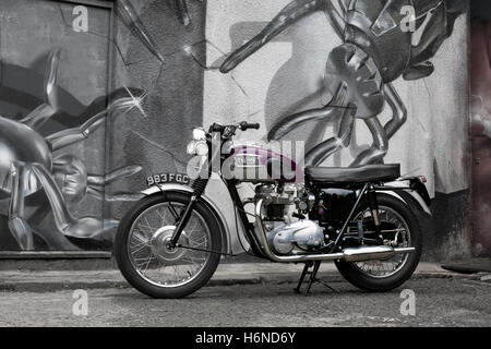 Motorrad-1963 Triumph Trophy TR6.  Lage in Camden Town London UK geparkt auf Straße mit street-Art im Hintergrund Stockfoto