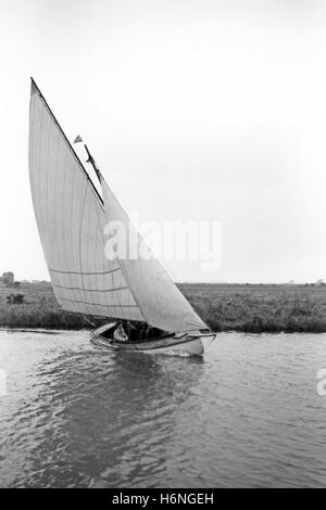 Kleine Yacht Segeln am Fluss in Norfolk, England Stockfoto