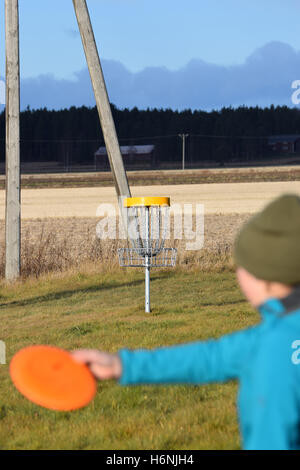 Junge Frau mit dem Ziel Scheibe auf Disc-Golf-Kurs. Im Ziel konzentrieren. Stockfoto