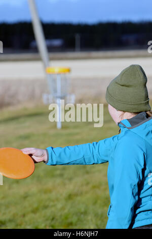 Junge Frau mit dem Ziel Scheibe auf Disc-Golf-Kurs. Person zu konzentrieren. Stockfoto