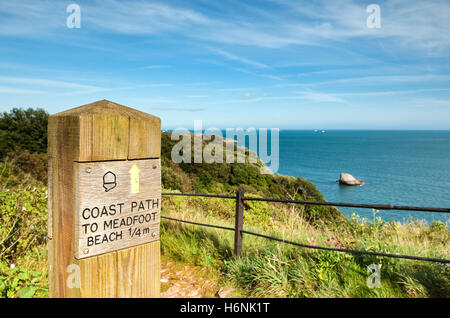 Coast Path' Strand 1/4 Meile' Schild weiter mit Meer- und Shag Rock im Hintergrund auf der klaren Sommer Tag Fußweg zu meadfoot. Stockfoto