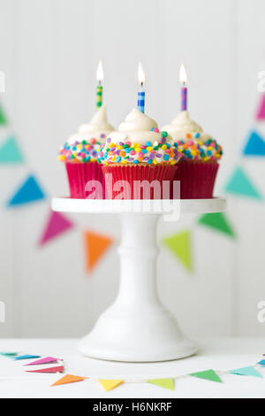 Bunte Geburtstag Cupcakes auf eine Kuchenplatte Stockfoto
