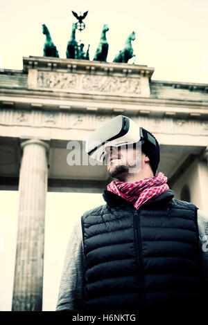 Mann mit Virtual Reality (VR) Brille vor dem Brandenburger Tor in Berlin, Deutschland Stockfoto