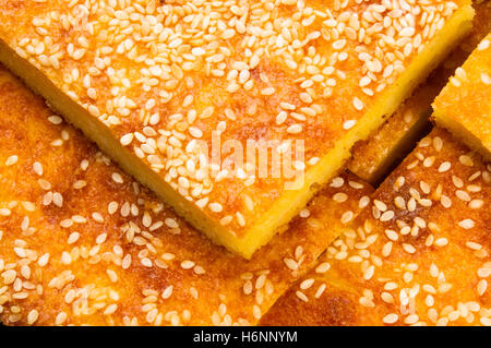 Stück Käsekuchen mit Sesam auf schwarzem Hintergrund Stockfoto