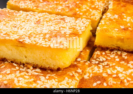 Stück Käsekuchen mit Sesam auf schwarzem Hintergrund Stockfoto