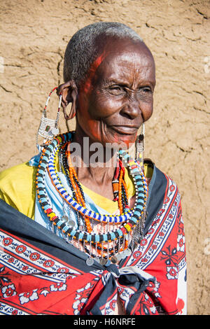 Maasai Seniorin mit gedehnte Ohrläppchen tragen traditionelle einheimische Kleidung, in einem Dorf in der Nähe der Masai Mara, Kenia, Afrika Stockfoto