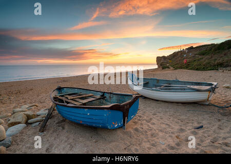 Atemberaubenden Sonnenuntergang über Angelboote/Fischerboote am Strand von Burton Bradstock in der Nähe von Bridport an der Küste von Dorset Stockfoto