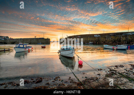 Sonnenaufgang über Angelboote/Fischerboote am Mousehole in der Nähe von Penznance an der Küste von Cornwall Stockfoto