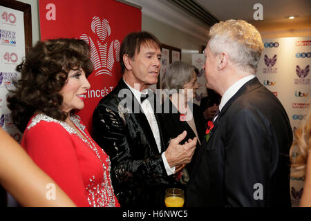 Dame Joan Collins (links) und Cliff Richard (zweiter von links) mit Louis Walsh (rechts) an den Prinzen Vertrauen Rezeption der 2016 Daily Mirror Pride of Britain Awards im Grosvenor House, Park Lane, London sprechen. Stockfoto