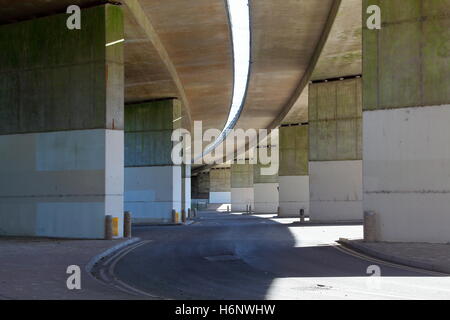 Suche entlang unter der Länge einer geschwungenen zweispurige Brücke mit einer Straße darunter scheint die Struktur zu folgen. Stockfoto