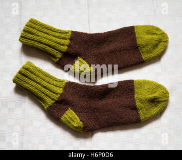 Paar bunte warme Wolle gestrickte Socken auf Leinen Hintergrund Stockfoto