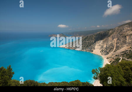 Blick auf Myrtos Strand, auf der griechischen Insel Kefalonia mit dem Dorf Assos in der Ferne Stockfoto