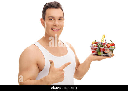 Fröhlicher Mensch hält einen kleinen Korb mit Obst und Gemüse einkaufen und zeigt isoliert auf weißem Hintergrund Stockfoto