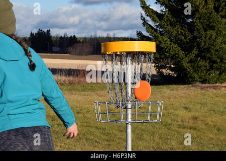 Frisbee zum Ziel auf Disc-Golf-Kurs. Stockfoto