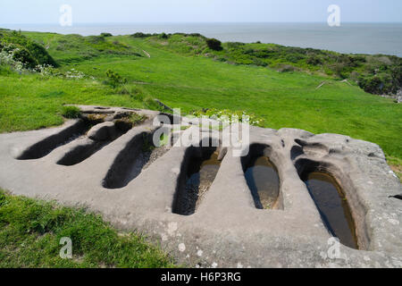 Sechs Körperangepasster Gräber geschnitten in einem Sandstein Felsen neben St Patricks C8th angelsächsischen Kapelle auf Heysham Barrows. Stockfoto