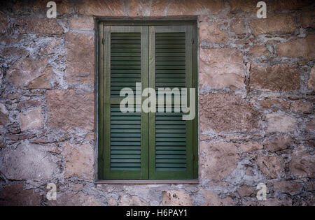 Alte grüne Fenster mit geschlossenen Fensterläden. Closeup. Stockfoto