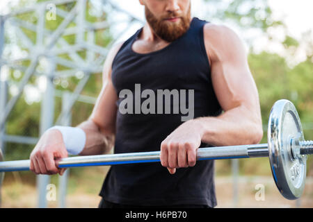 Bild von einem schweren bärtigen Jüngling Sportler trainieren und im freien Hantel heben beschnitten Stockfoto