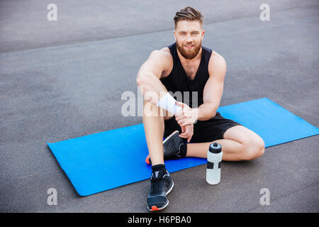 Schönen jungen Mann glücklich Athlet ruhen und Trinkwasser nach Training im freien Stockfoto