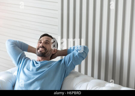 Mich glücklich hält seine Hände hinter dem Kopf Stockfoto