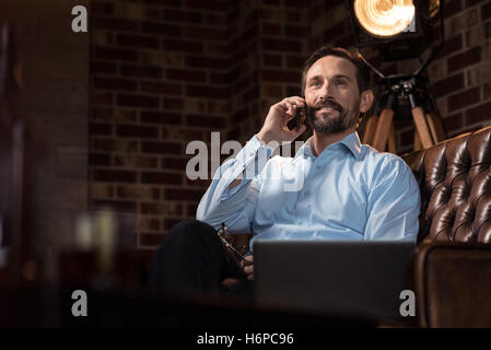 Positive schöne Geschäftsmann hält eine smartphone Stockfoto