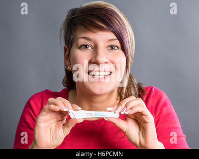 Schwangerschaftstest - glücklich überrascht Frau Stockfoto