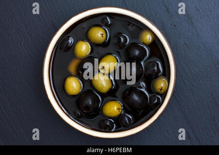 Schüssel mit gemischten Oliven in Keramikschale von oben. Stockfoto