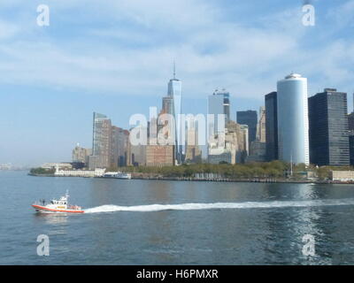 US-Küstenwache patrouillieren in New York Harbor mit Innenstadtbüro Türmen Stockfoto