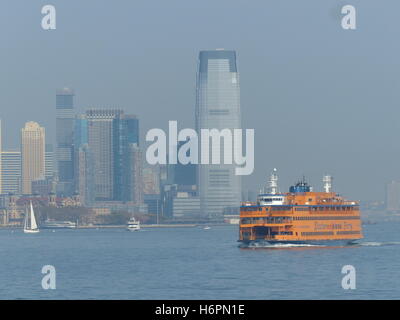 Staten Island Ferry lehnt sich zu Recht als Touristen drängen sich die Steuerbordseite zu fotografieren Statue of Liberty Stockfoto