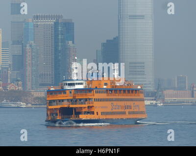 Staten Island Ferry lehnt sich zu Recht als Touristen drängen sich die Steuerbordseite zu fotografieren Statue of Liberty Stockfoto