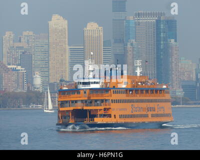 Staten Island Ferry lehnt sich zu Recht als Touristen drängen sich die Steuerbordseite zu fotografieren Statue of Liberty Stockfoto