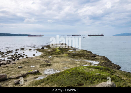 Blick vom Ufer des Vancouver British Columbia Kanada Ozean gehen Fracht Schiffe warten in English Bay. Stockfoto