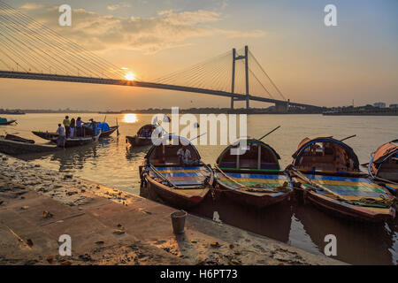 Boote aus Holz Land für Vergnügen Bootsfahrten bei Sonnenuntergang am Princep Ghat am Fluss Hooghly aufgereiht. Stockfoto