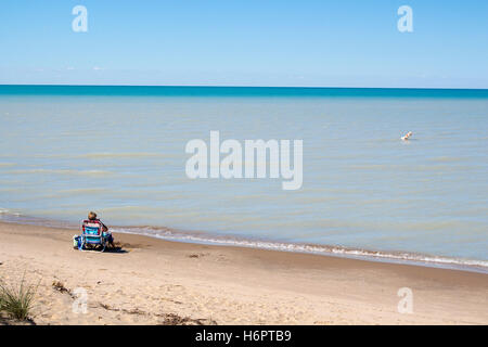 Mann am Strand mit Handy Lokoing, Lake Huron und Sandbänke Stockfoto