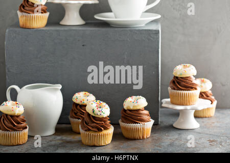 Muffins mit Schokolade Zuckerguss und kleine donuts Stockfoto