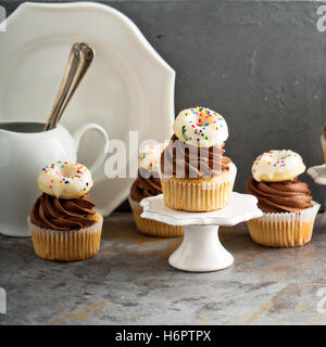 Muffins mit Schokolade Zuckerguss und kleine donuts Stockfoto