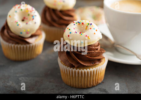 Muffins mit Schokolade Zuckerguss und kleine donuts Stockfoto