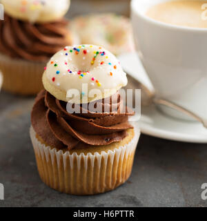 Muffins mit Schokolade Zuckerguss und kleine donuts Stockfoto