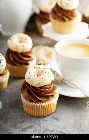 Muffins mit Schokolade Zuckerguss und kleine donuts Stockfoto