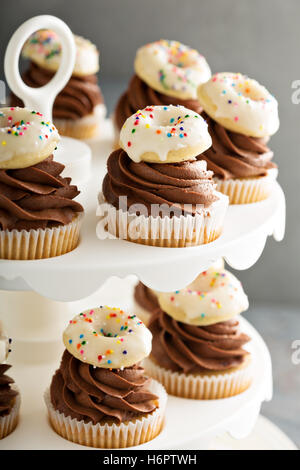 Muffins mit Schokolade Zuckerguss und kleine donuts Stockfoto